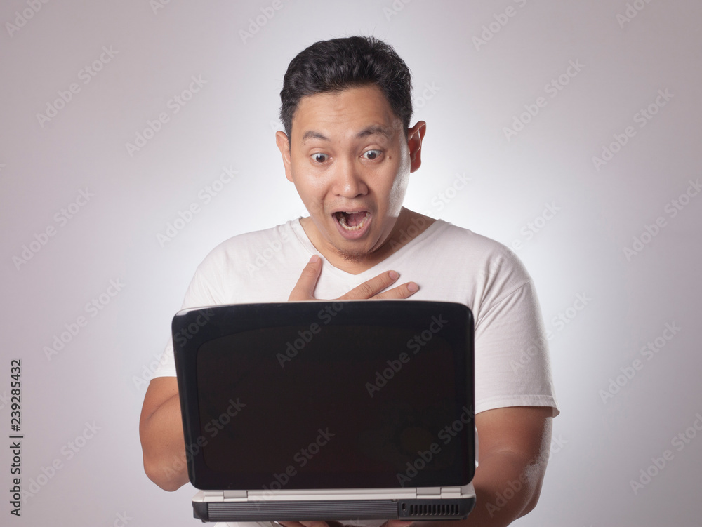 Young Man Looking at Laptop, Surprised Expression