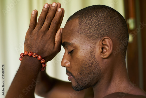 Photography portrait of a handsome african american male put praying hands to his forehead