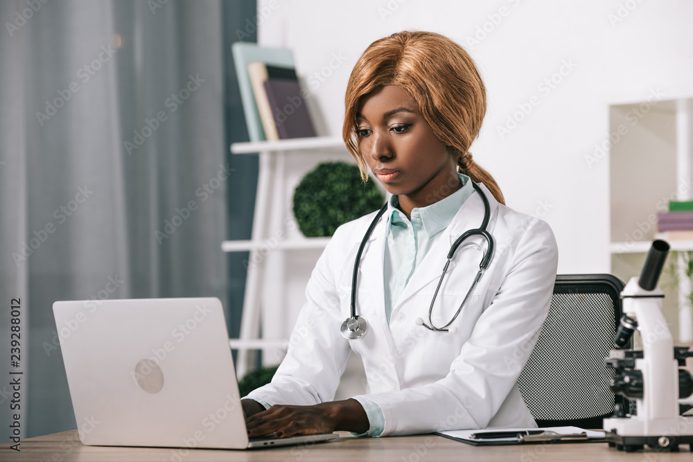 female african american scientist typing on laptop female african american scientist typing on laptop