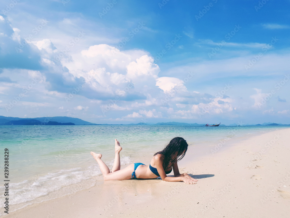 Beautiful woman in bikini laying on the paradise beach