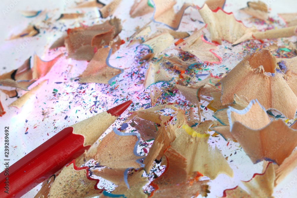 red pencil on a background of multicolored shavings close-up / sharpened for work red pencil on a background of multicolored shavings close-up / sharpened for work