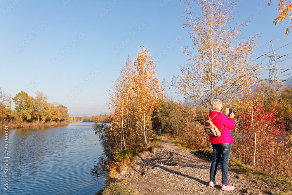 Locals hiking and photographing at autumnal banks of Old Rhine Locals hiking and photographing at autumnal banks of Old Rhine