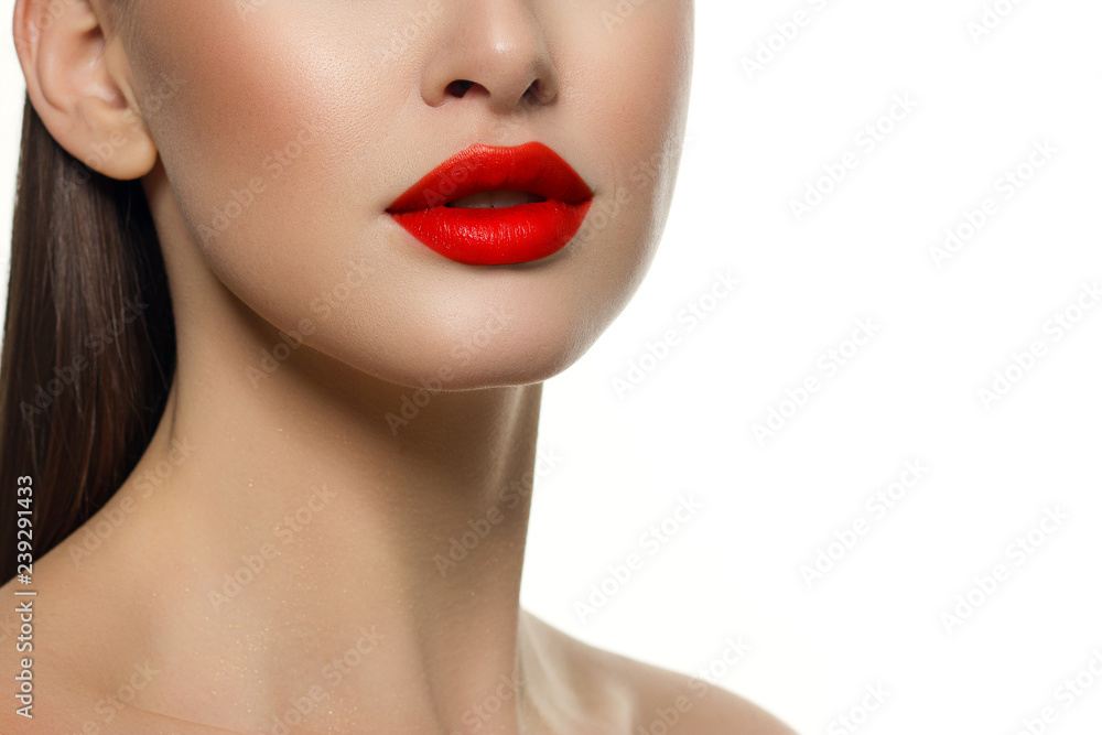 Cosmetics, makeup and trends. Bright lip gloss and lipstick on lips. Closeup of beautiful female mouth with red lip makeup. Beautiful part of female face. Perfect clean skin in red light Cosmetics, makeup and trends. Bright lip gloss and lipstick on lips. Closeup of beautiful female mouth with red lip makeup. Beautiful part of female face. Perfect clean skin in red light