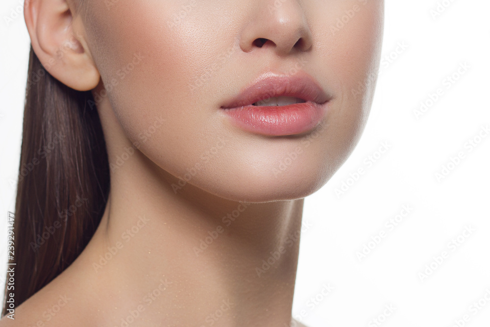 Cosmetics, makeup and trends. Bright lip gloss and lipstick on lips. Closeup of beautiful female mouth with natural lip makeup. Beautiful part of female face. Perfect clean skin in natural light Cosmetics, makeup and trends. Bright lip gloss and lipstick on lips. Closeup of beautiful female mouth with natural lip makeup. Beautiful part of female face. Perfect clean skin in natural light