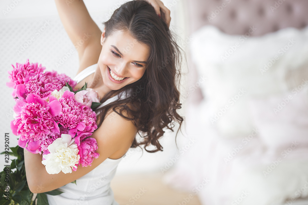 Young beautiful woman holding flowers. Attractive girl with peony pink. Beauty portrait. Female close up portrait Young beautiful woman holding flowers. Attractive girl with peony pink. Beauty portrait. Female close up portrait