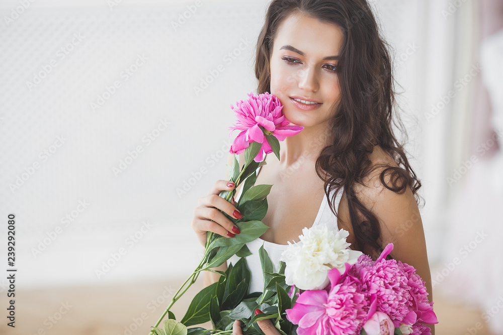Young beautiful woman holding flowers. Attractive girl with peony pink. Beauty portrait. Female close up portrait Young beautiful woman holding flowers. Attractive girl with peony pink. Beauty portrait. Female close up portrait