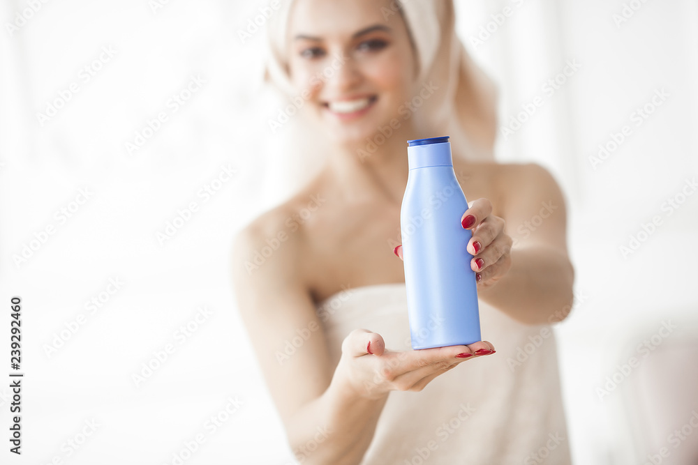 Young attractive woman after bathing. Female in towels. Beautiful lady moisturizing her body with body lotion. Portrait of young girl in the bethroom Young attractive woman after bathing. Female in towels. Beautiful lady moisturizing her body with body lotion. Portrait of young girl in the bethroom