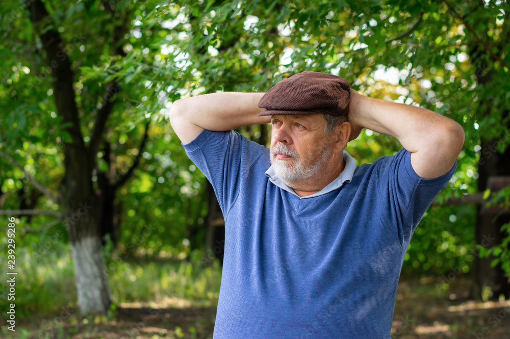 Outdoor portrait of bearded senior man resting in tree shadow Outdoor portrait of bearded senior man resting in tree shadow
