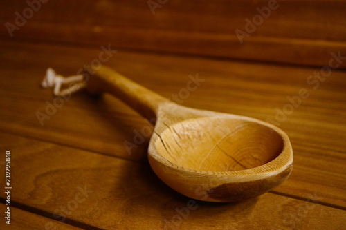 Sauna equipment wooden ladle, close up. Wooden spoon in the spa bathhouse interior.