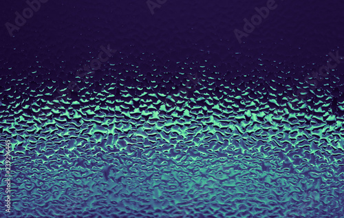 Blue abstract water drops background. Violet green wet glass, condensate texture background.