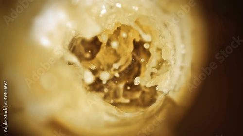 Closeup slow-motion pouring beer in pint glass photo