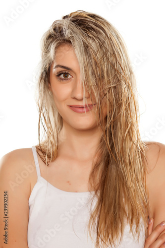 smiling blond woman with wet hair on white background