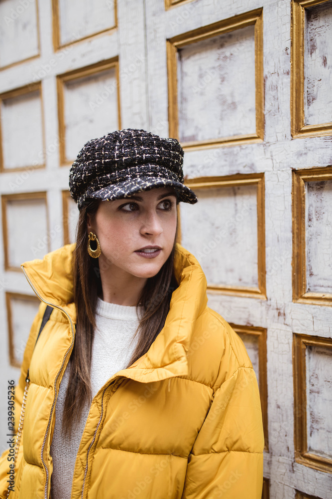 Brunette young woman in trendy outfit standing near wooden wall Brunette young woman in trendy outfit standing near wooden wall
