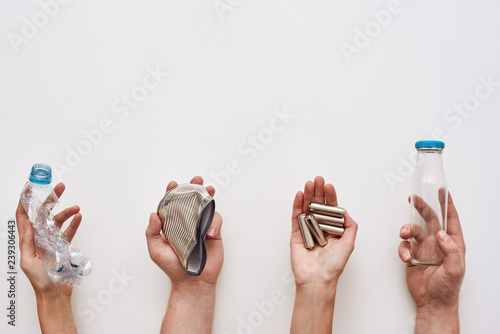 Fotografie Sparate your trash. Four types of garbage in human hands
