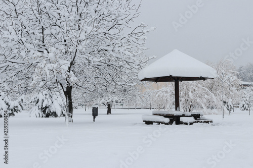 Snow landscape. Bench and canopy in an empty park covered with s photo