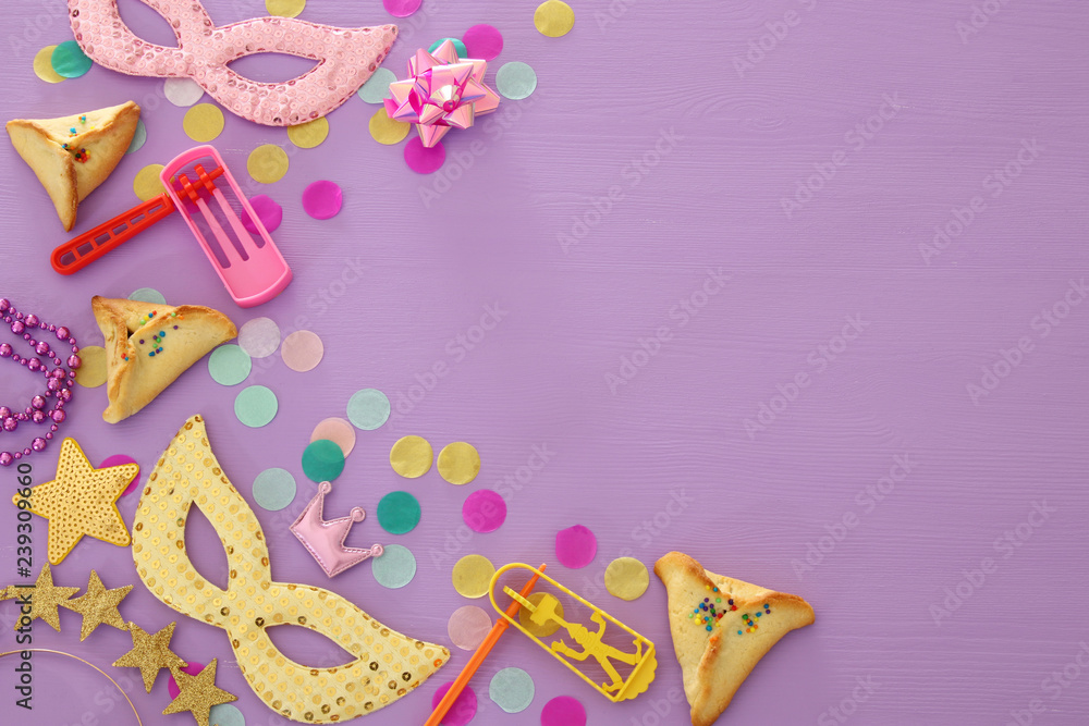 Purim celebration concept (jewish carnival holiday) over purple, pink wooden background. Top view. Purim celebration concept (jewish carnival holiday) over purple, pink wooden background. Top view.