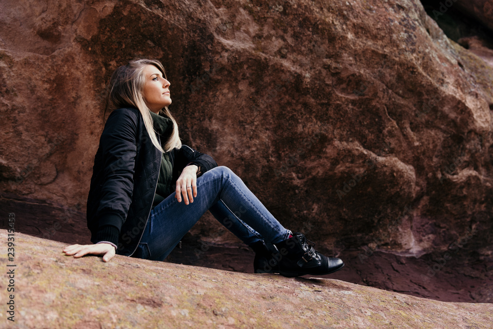Young Cute Modern Caucasian Woman Smiling in Front of Massive Natural Red Rock Stone Wall Outside in Nature at the State Park Young Cute Modern Caucasian Woman Smiling in Front of Massive Natural Red Rock Stone Wall Outside in Nature at the State Park
