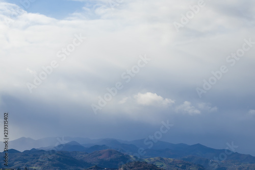 Mountain range in clear weather in contrasting rain clouds before the rain