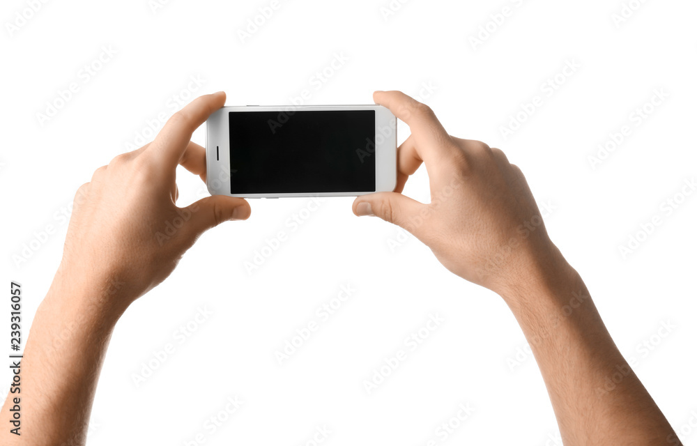 Young man holding mobile phone on white background