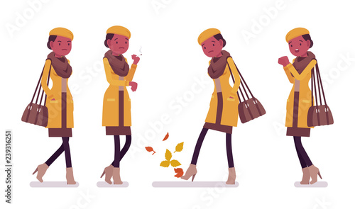 Stylish young black woman smoking, feeling cold, wearing autumn clothes