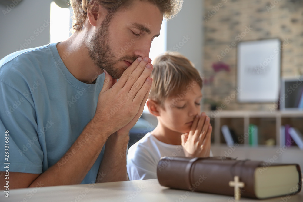 Father with son praying at home Father with son praying at home
