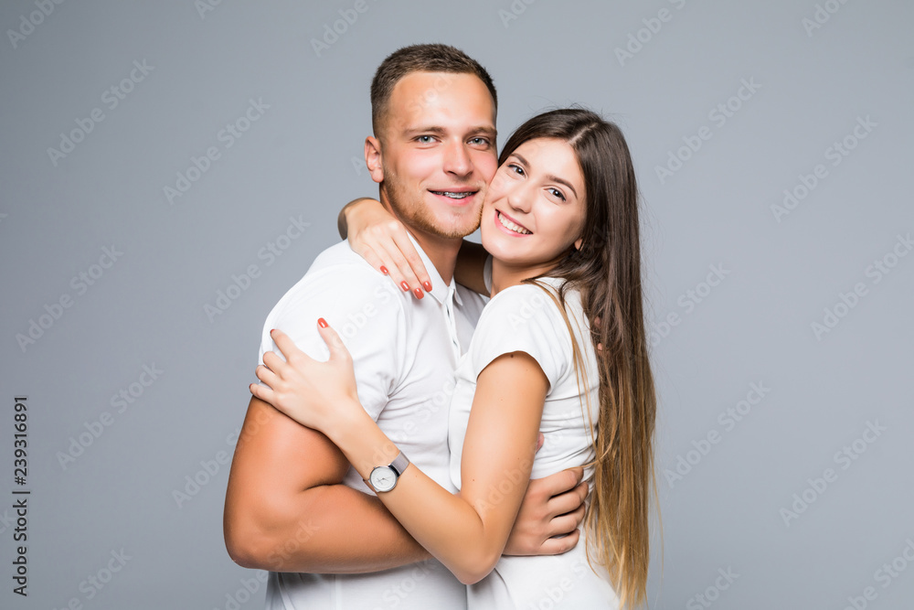 Portrait of happy couple looking at camera against gray background Portrait of happy couple looking at camera against gray background