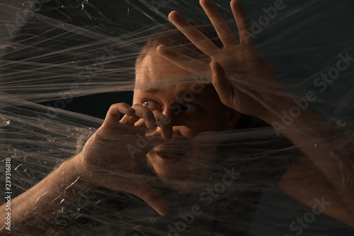 Frightened man behind plast...