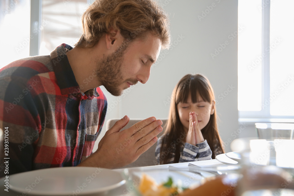 Father with daughter praying before meal at home Father with daughter praying before meal at home