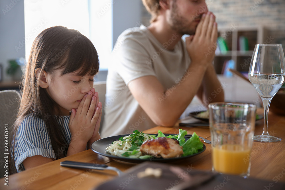 Family praying before meal at home Family praying before meal at home