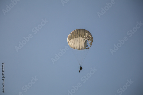 Jump of paratrooper with white parachute, Military parachute jumper in the sky.