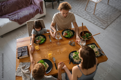 Family praying before meal ...