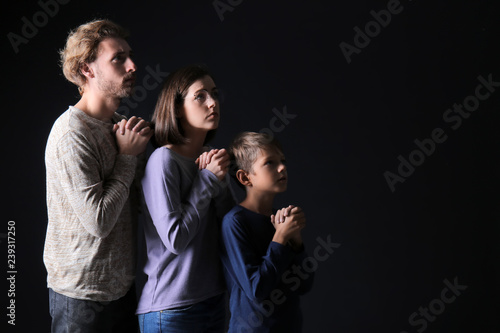 Praying family on dark back...