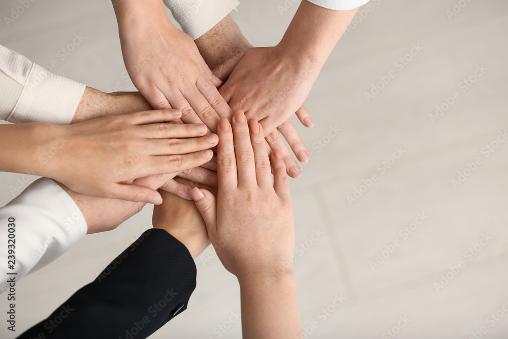 Fototapeta premium People putting hands together on light background