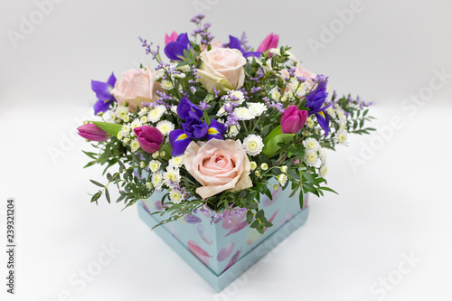 Delicate bouquet of flowers (roses, tulips, irises) in a box
