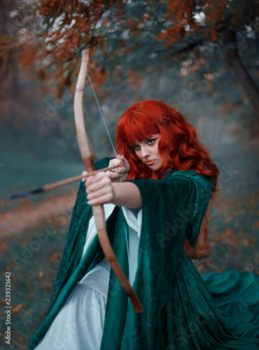 brave red-haired girl holds a bow in her hands, directing an arrow, experienced hunter goes into battle, warlike image of the princess in emerald cloak and white dress, art in cold colors, Gothic fog © kharchenkoirina