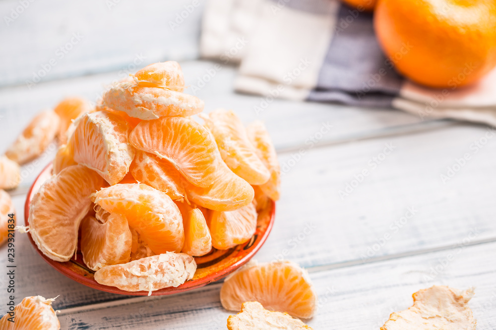 Fresh pieces of tangerines mandarin on the plate or in a bowl Fresh pieces of tangerines mandarin on the plate or in a bowl