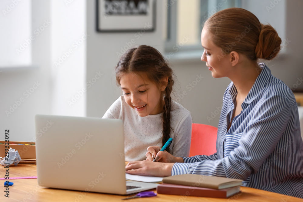 Cute girl with mother doing homework at home Cute girl with mother doing homework at home