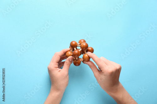 Female hands with brain teaser on color background photo