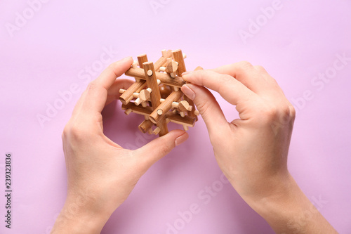 Billede på lærred Female hands with brain teaser on color background