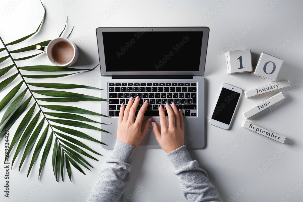 Young woman using laptop on white table, top view Young woman using laptop on white table, top view