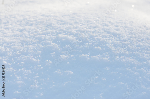 White blue snow texture background with bokeh. Close up of fresh clean snow with blue shadows. Selective focus