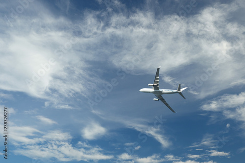 Airplane flying in blue sky and clouds