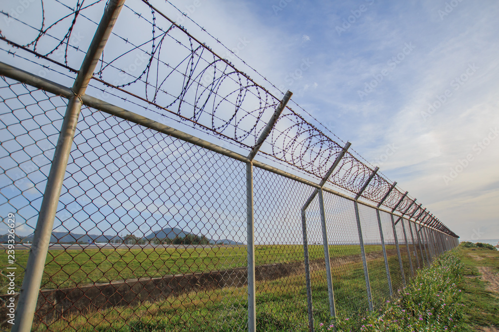 Obraz premium Chain link fence with grass field Phuket International Airport