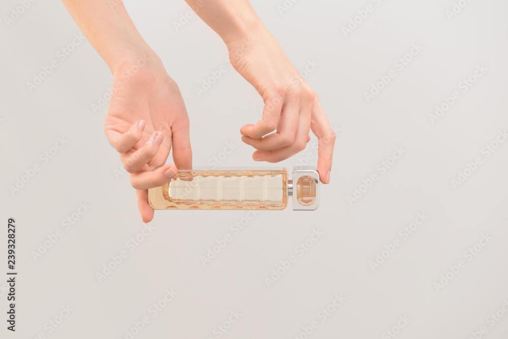 Obraz premium Woman holding bottle of perfume on color background