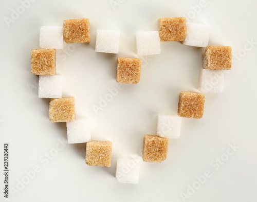 Heart made with different cubes of sugar on white background