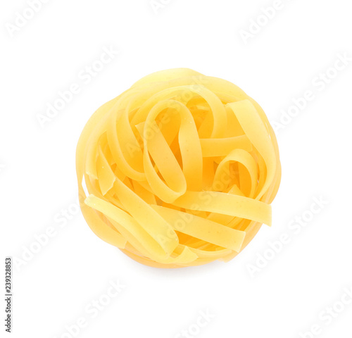 Uncooked fettuccine pasta on white background