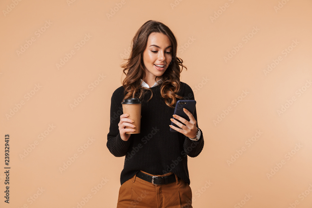 Smiling young woman wearing sweater standing - obrazy, fototapety, plakaty 