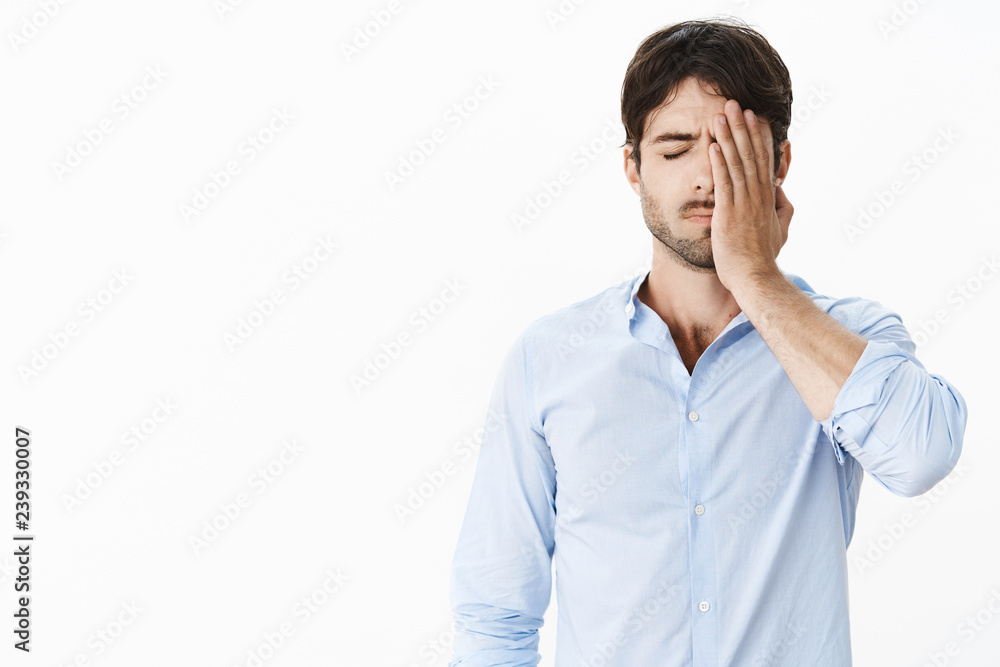 Guy feeling sad missing opportunity of lifetime being guilty and upset making facepalm gesture with hand on face standing with closed eyes feeling drained and uneasy after failure being fired Guy feeling sad missing opportunity of lifetime being guilty and upset making facepalm gesture with hand on face standing with closed eyes feeling drained and uneasy after failure being fired