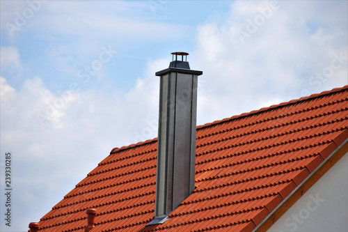 Chimney with stainless steel cladding on a new tiled roof