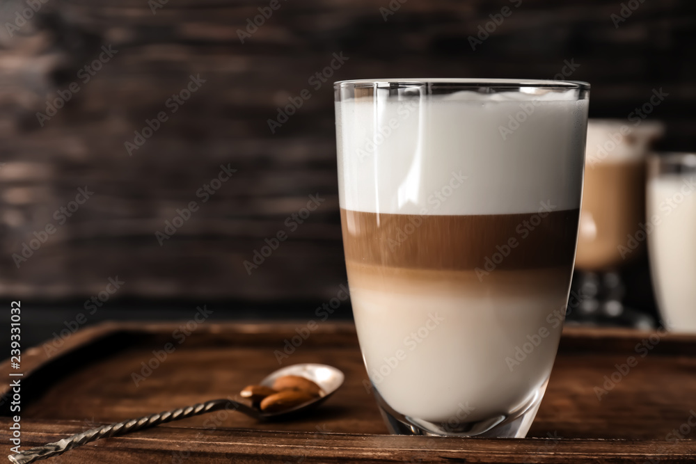 Glass of tasty aromatic latte on wooden board - obrazy, fototapety, plakaty 